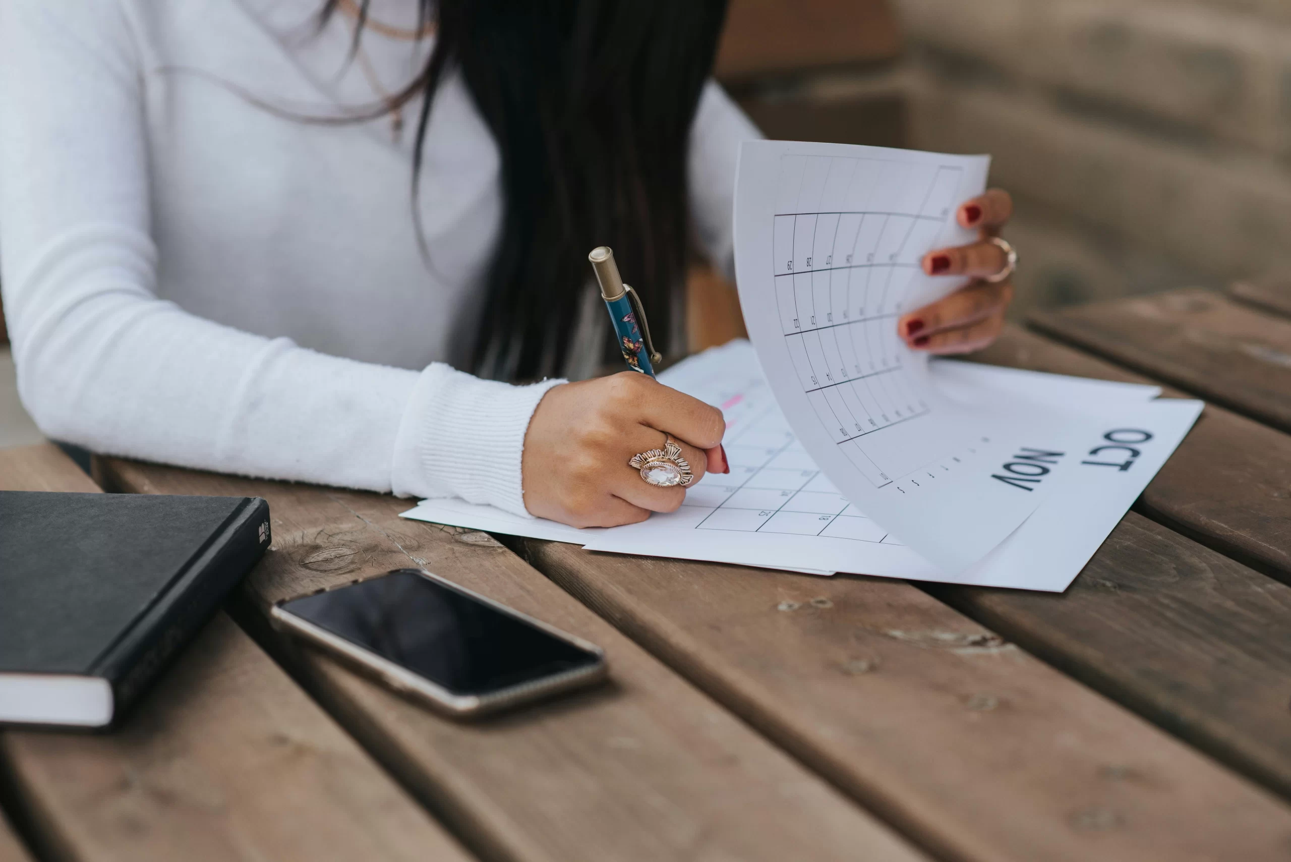 A parent creating a plan and schedules on a calendar.