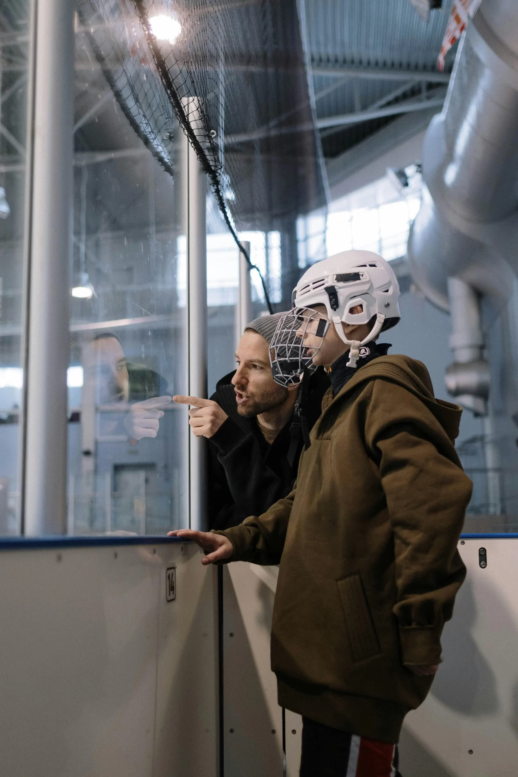 Father and son talking about the best strategies to win the game in hockey.