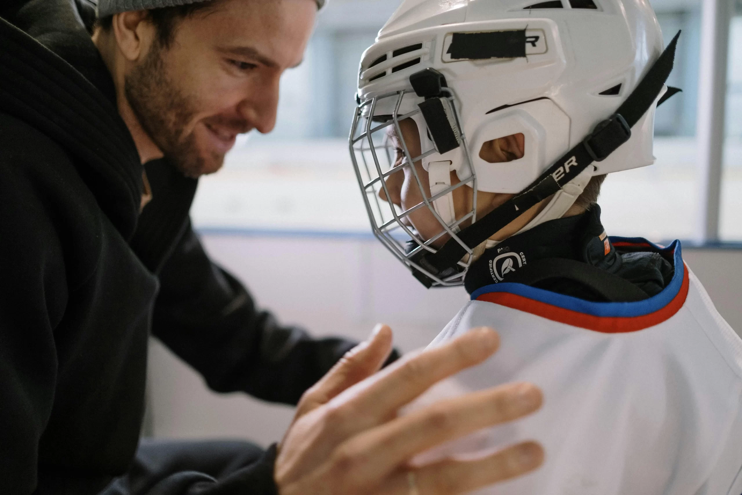 Father and son talking after a game of hockey.