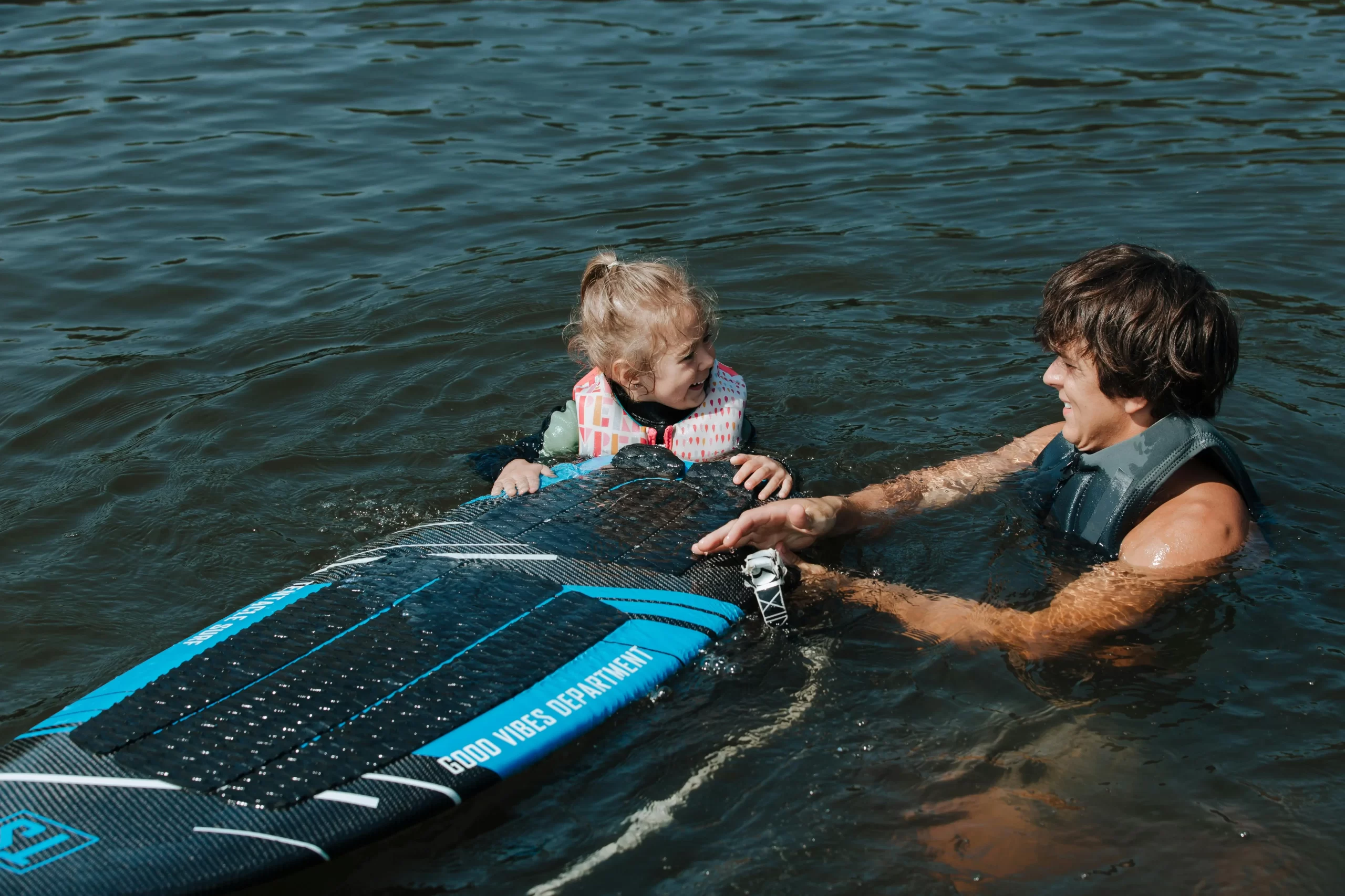 Father and daughter on the beach enjoying surfing.